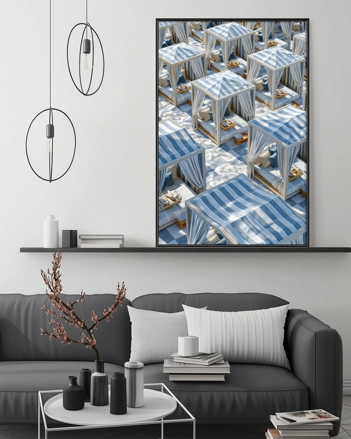 a modern living room with a gray sofa, a coffee table, and a large framed print of a beach scene with lounge chairs and umbrellas.