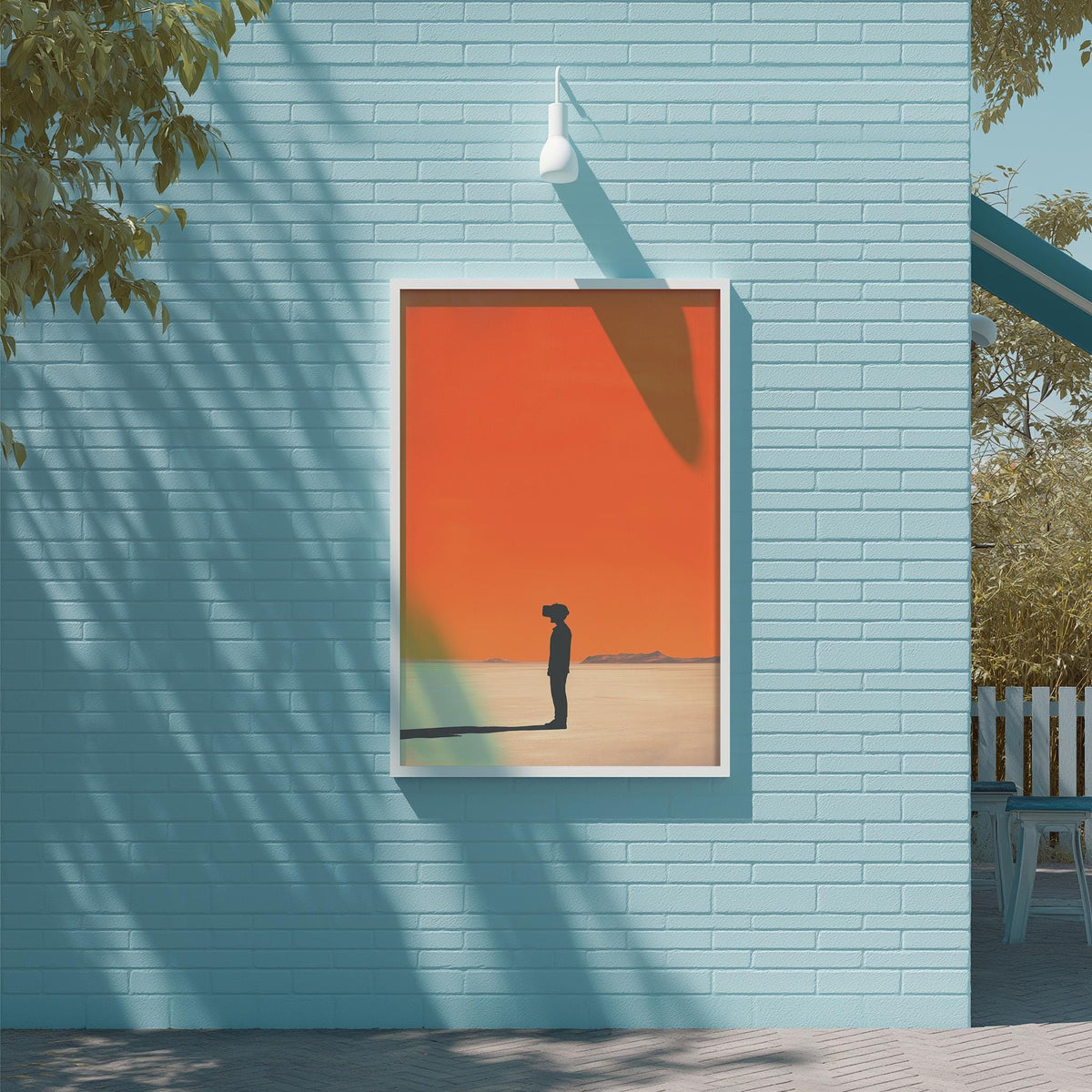 a blue brick wall with a framed picture of a person standing in front of a sunset.