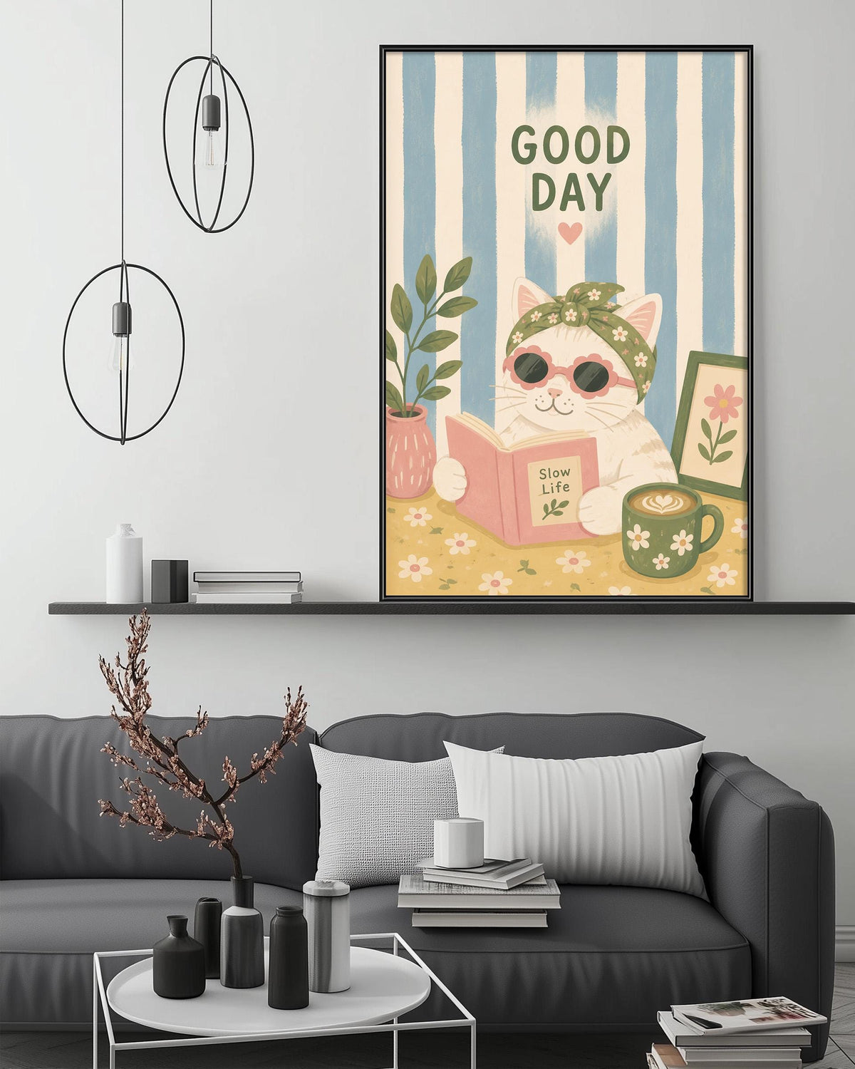 a cozy living room with a gray couch, a coffee table, and a framed poster of a cat reading a book. The poster has a whimsical design with a cat wearing sunglasses and the text "Good Day" written above it.
