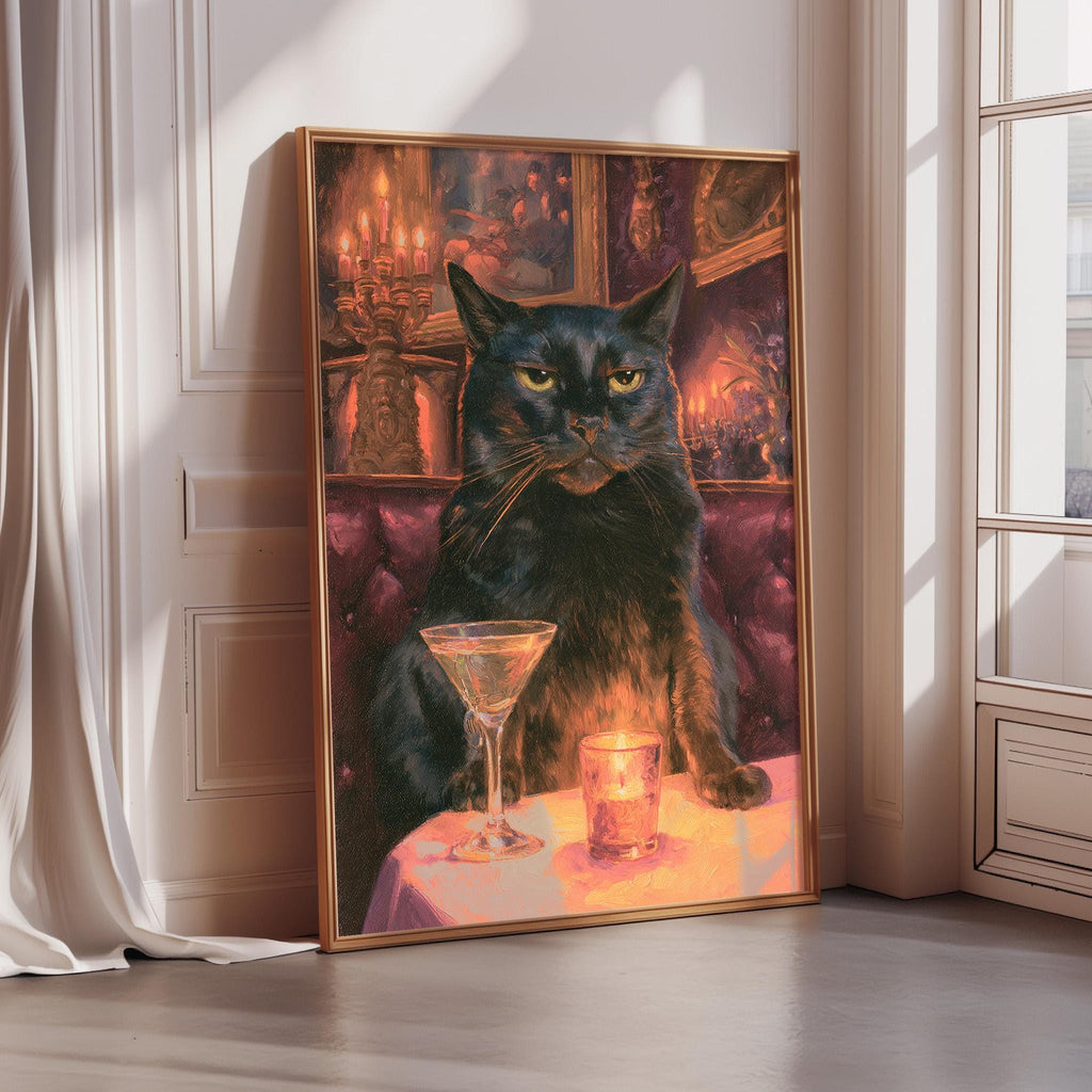 A framed painting depicting a black cat sitting at a table with a martini glass and a candle, set against a warm, colorful background.