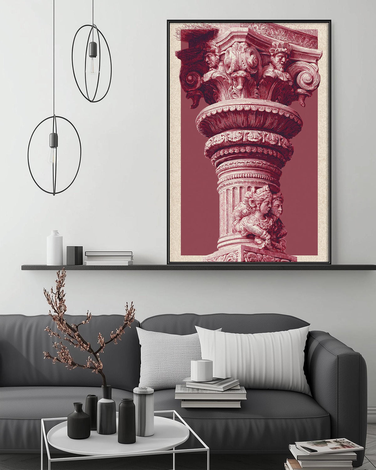 a large, ornate, and intricately decorated column or pillar, which is the central focus of the scene. The column is displayed in a framed artwork, which is hung on a wall above a gray couch. The couch is positioned in front of a coffee table, which has various decorative items such as vases, a plant, and a stack of books. The overall setting appears to be a cozy and stylish living room.