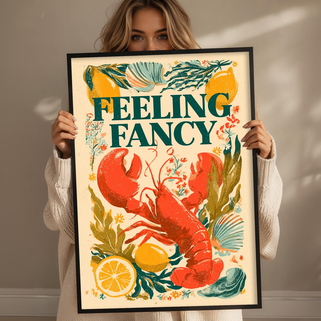 A woman holding a framed poster with a lobster and various colorful elements, including lemon slices and flowers.