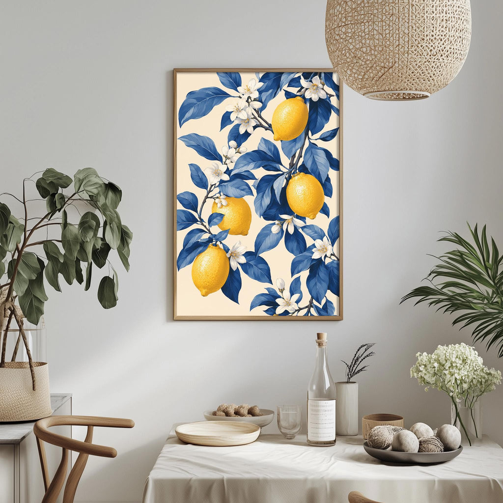 a dining table with a white tablecloth, a bowl of fruit, a bottle, and a vase with flowers. Above the table, there is a framed picture of lemons and blue flowers hanging on the wall.