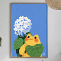 a framed illustration of a frog holding a bunch of white flowers, set against a blue background. The frog is surrounded by green leaves, and the flowers are blooming. The scene is set in a dining area with a table, chairs, and various decorative elements such as potted plants and vases.