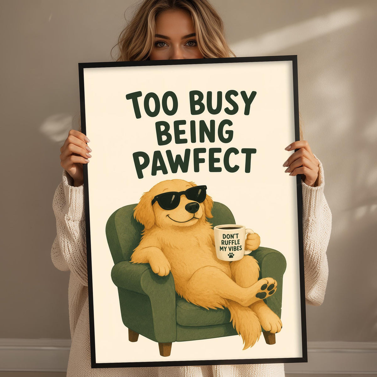 A woman is holding up a framed poster with an illustration of a dog sitting in a chair and wearing sunglasses.
