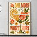 a framed poster with a vibrant design of a cocktail glass, citrus fruits, flowers, and the text "ONE MORE WON'T HURT" displayed on a wall above a gray couch in a living room setting.