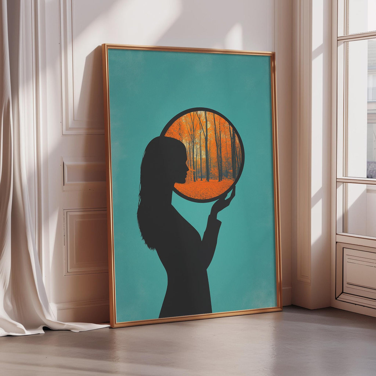 a framed artwork depicting a silhouette of a person holding a circular frame with an orange and green autumn landscape inside it.