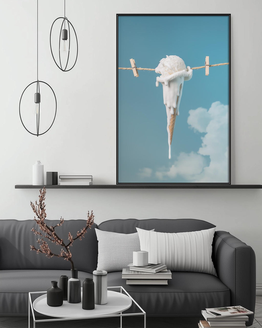 a modern living room with a gray sofa, a coffee table, and a large framed picture of an ice cream cone hanging from a clothesline.