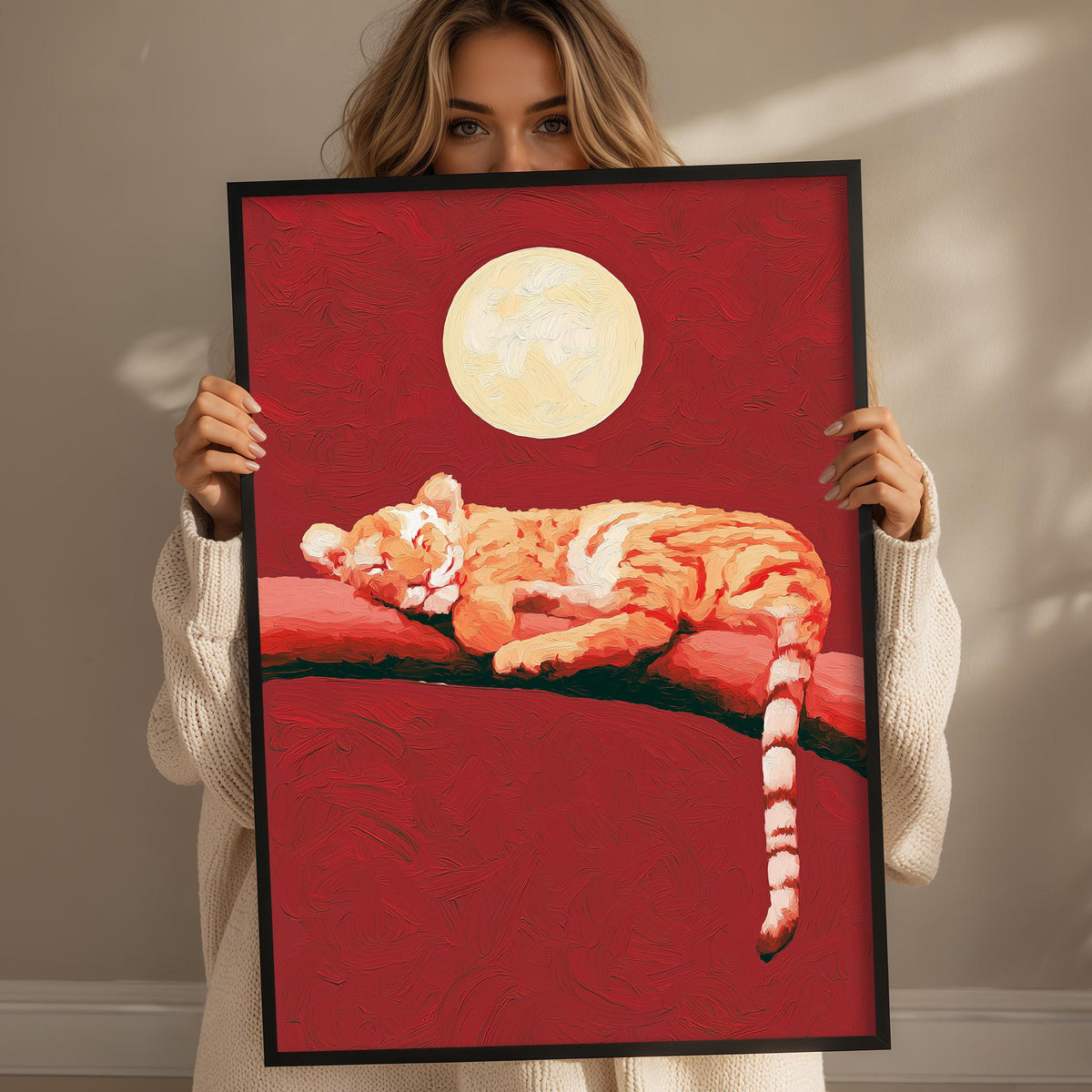 A woman holds up a framed painting of a sleeping tiger against a red background with a full moon.