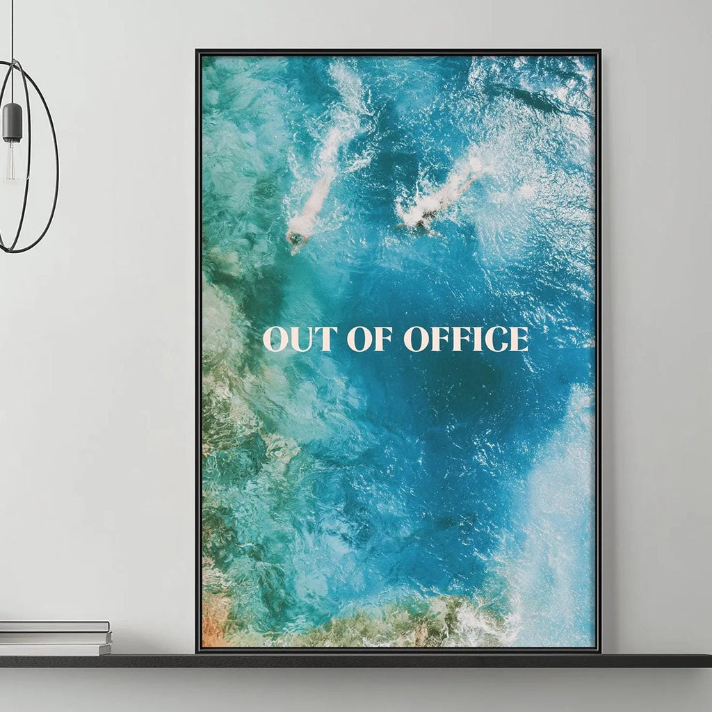 a modern living room with a gray sofa, a coffee table, and a large framed poster of a blue ocean scene with the text "OUT OF OFFICE" displayed on it.