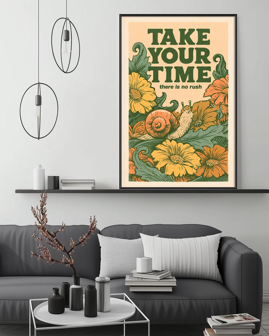 a framed poster with a vibrant floral design and the text "Take your time" above it, hanging on a wall above a gray couch with decorative items on a coffee table in a living room setting.