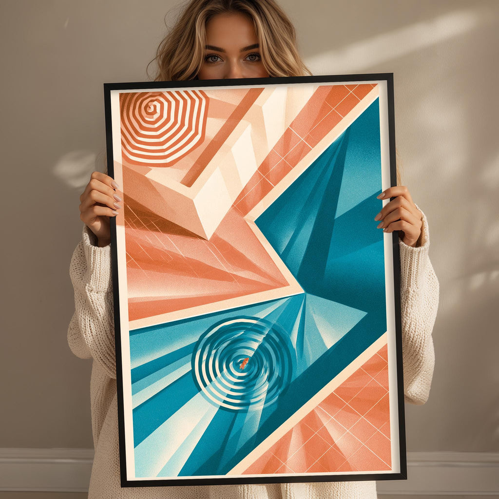 A woman is holding up a framed abstract art piece with a geometric design in shades of orange, blue, and white.