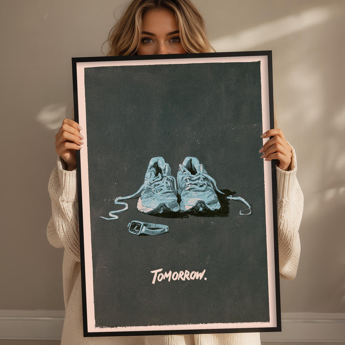 A woman holds up a framed poster with a pair of blue sneakers on it, and the word "tomorrow" written below the image.