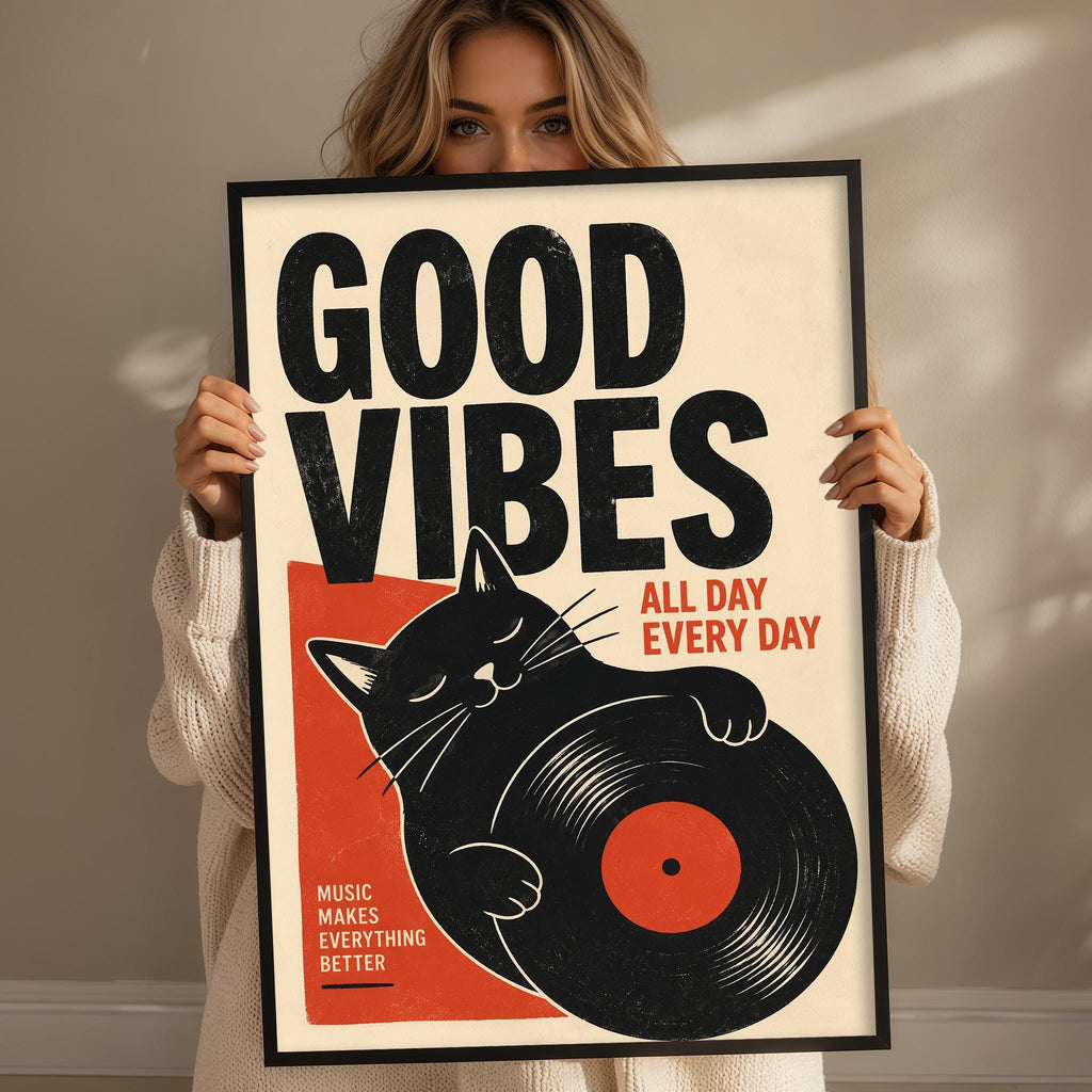 A woman holding a framed poster with a cat and the text "GOOD VIBES ALL DAY EVERY DAY"