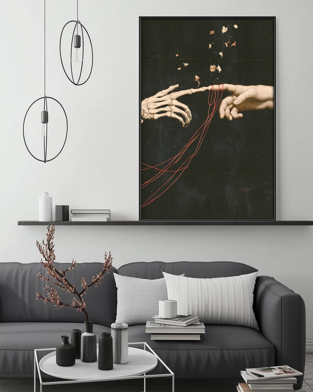 a modern living room with a gray sofa, a coffee table, and a large framed artwork depicting two skeletal hands reaching towards each other.
