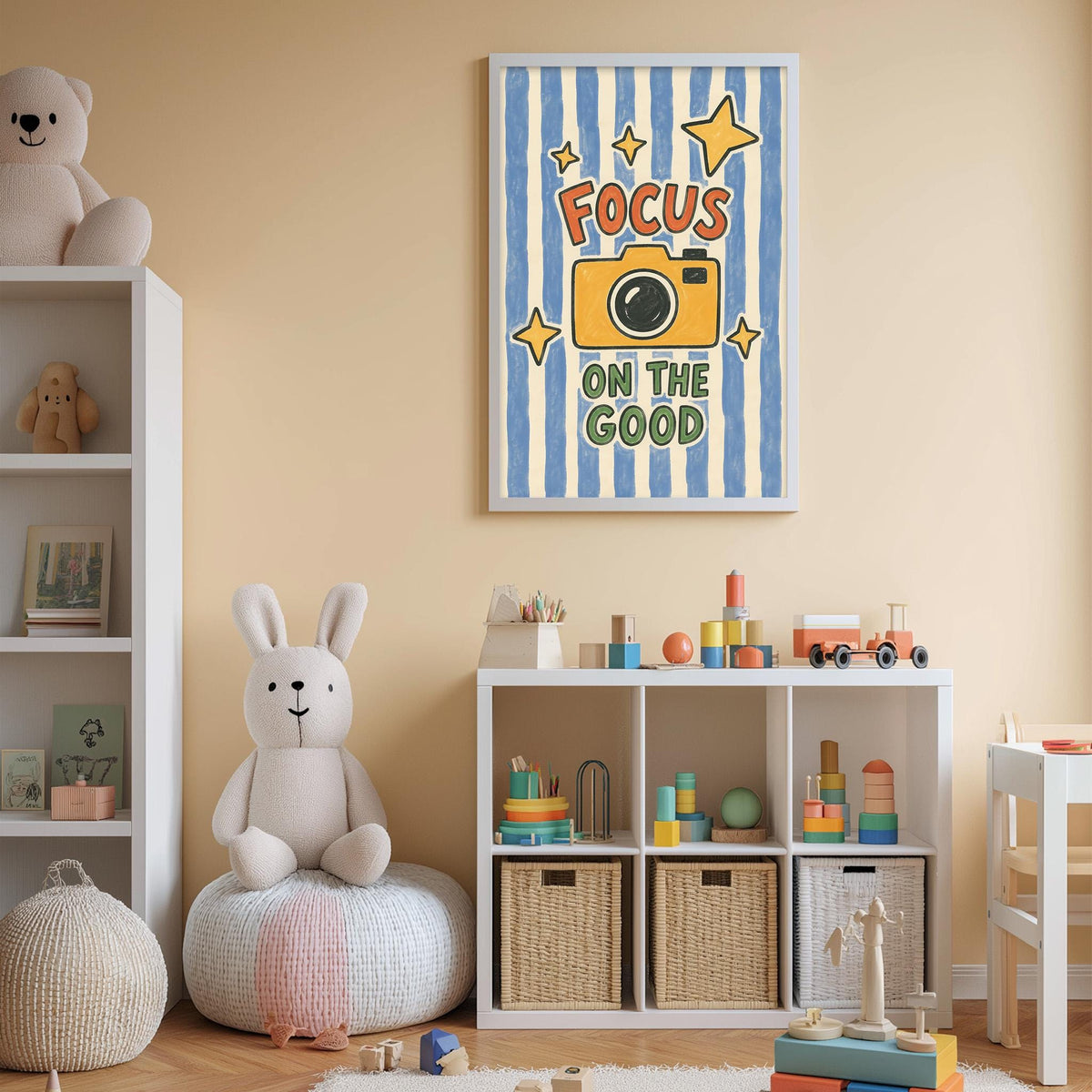 A child's bedroom with a white bookshelf, a stuffed rabbit, a toy train, and a framed poster with the text "Focus on the good" on the wall.