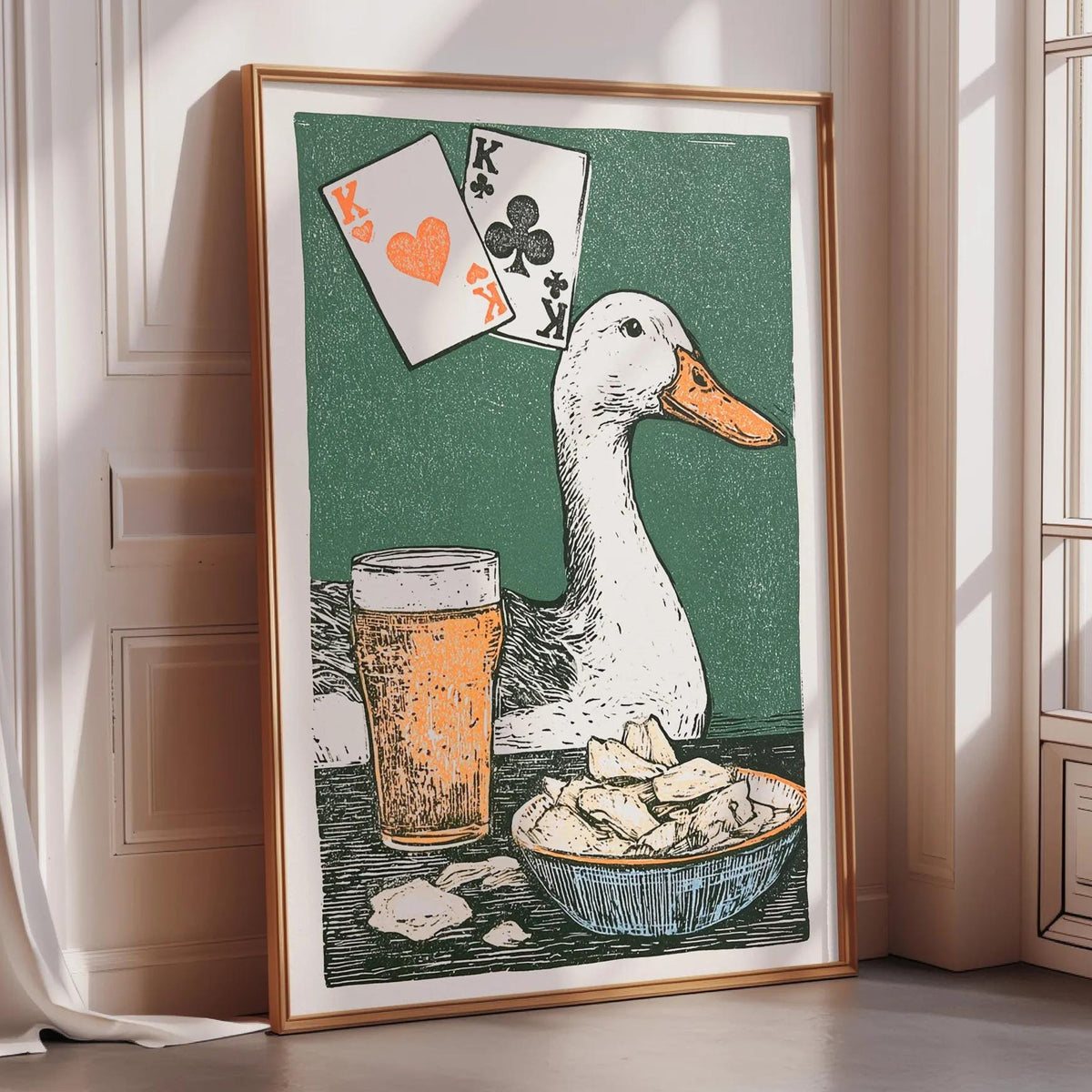 a framed illustration of a duck sitting next to a beer glass and a bowl of chips, with playing cards and a deck of cards displayed above the duck.
