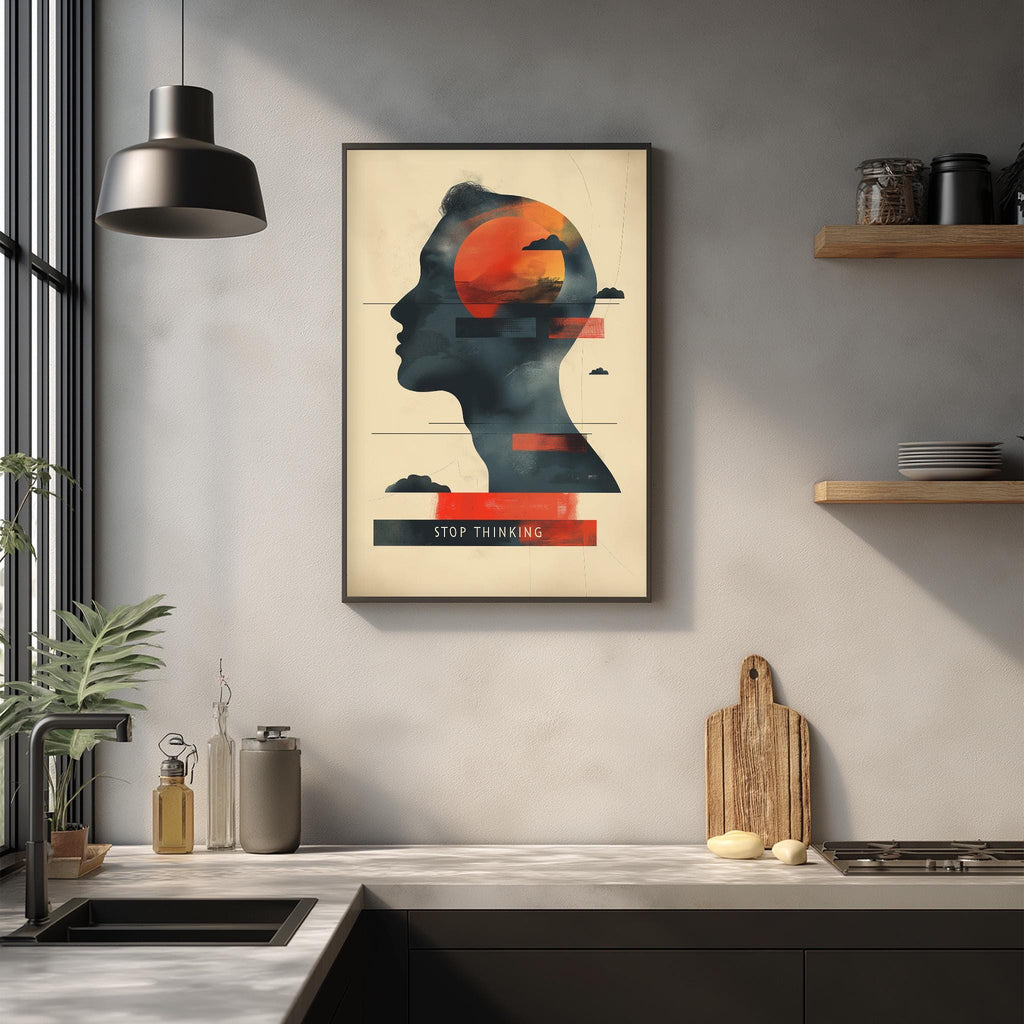 a framed poster with a silhouette of a person's head and the text "STOP THINKING" on it, hanging on a wall above a kitchen counter with various kitchen items and decor.
