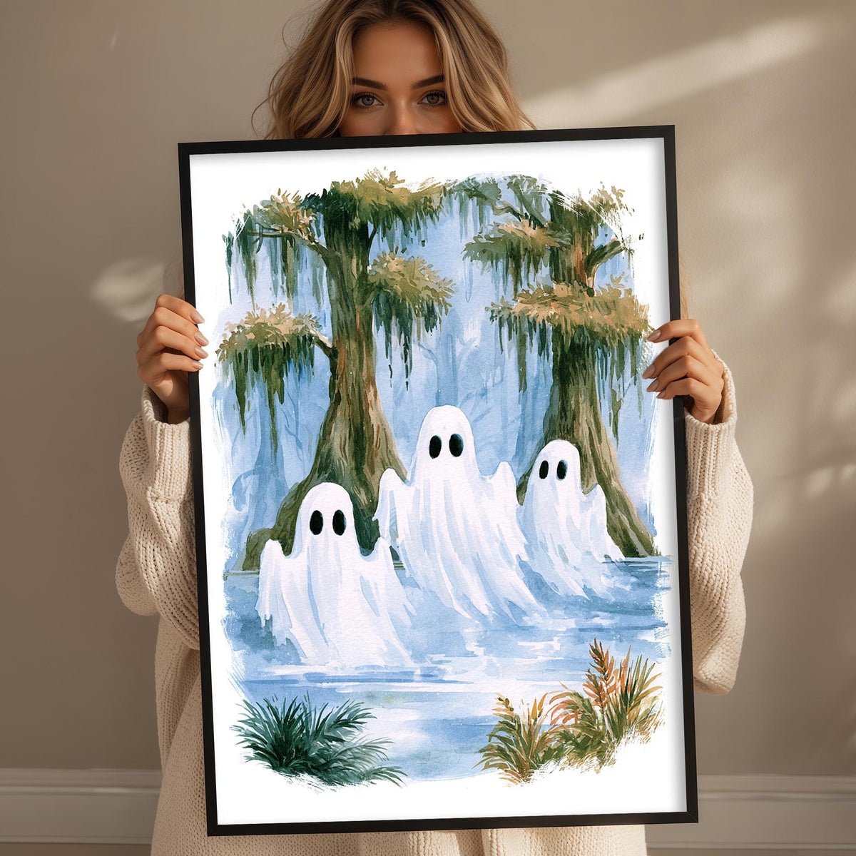 A woman holds up a framed painting depicting three ghostly figures floating in a swampy, swampy landscape with trees and greenery.