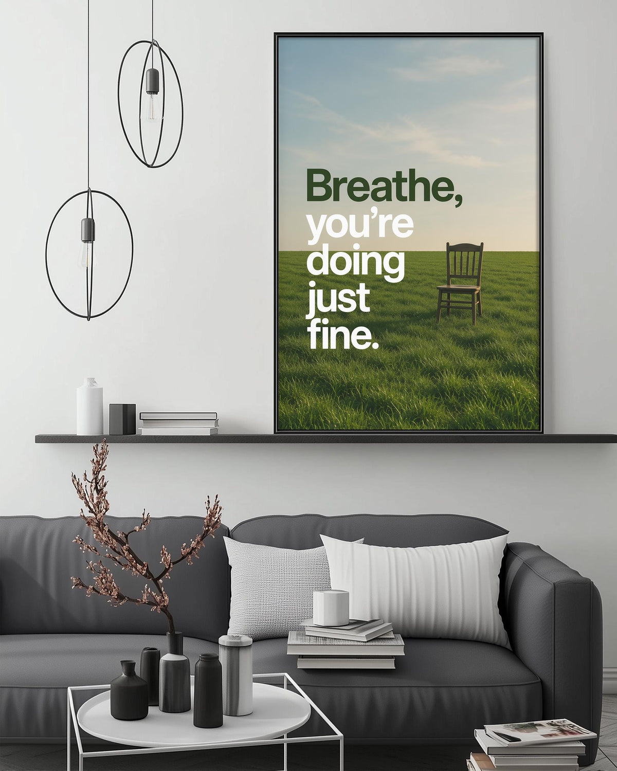 a living room with a gray sofa, a coffee table, and a large framed poster on the wall with the text "Breathe, you're doing just fine."