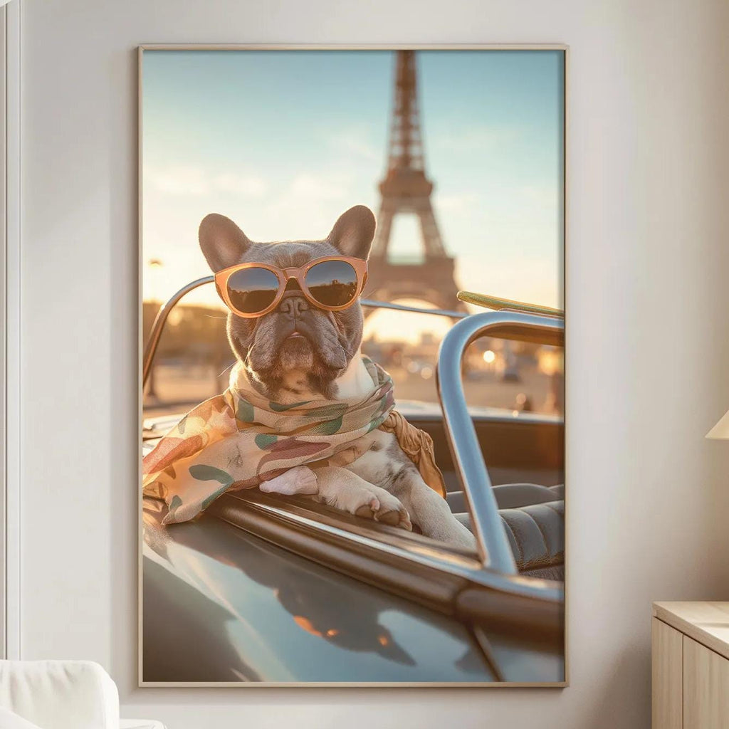 A framed photograph of a dog wearing sunglasses and a scarf, sitting in the front seat of a car, with the Eiffel Tower visible in the background.