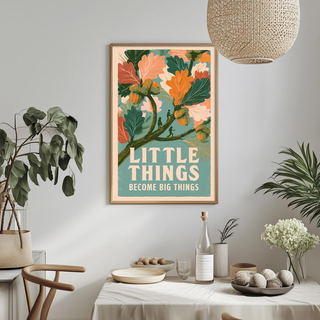 a framed poster with a vibrant floral design hanging on a wall above a dining table. The poster has the text "LITTLE THINGS BECOME BIG THINGS" written on it. The dining table is set with various items, including a bottle, a bowl, and a vase, creating a cozy and inviting atmosphere.