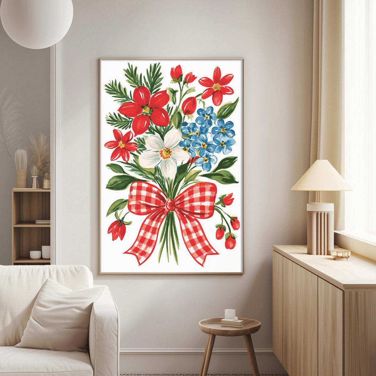 a living room with a large framed print of a floral arrangement hanging on the wall. The print depicts a bouquet of red, white, and blue flowers, along with green leaves and a red and white checkered bow. The room has a white couch, a wooden side table, and a lamp on a nearby table.
