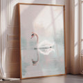 A large framed print of a swan swimming in a body of water is displayed on a wall in a room with sunlight streaming in through a window.