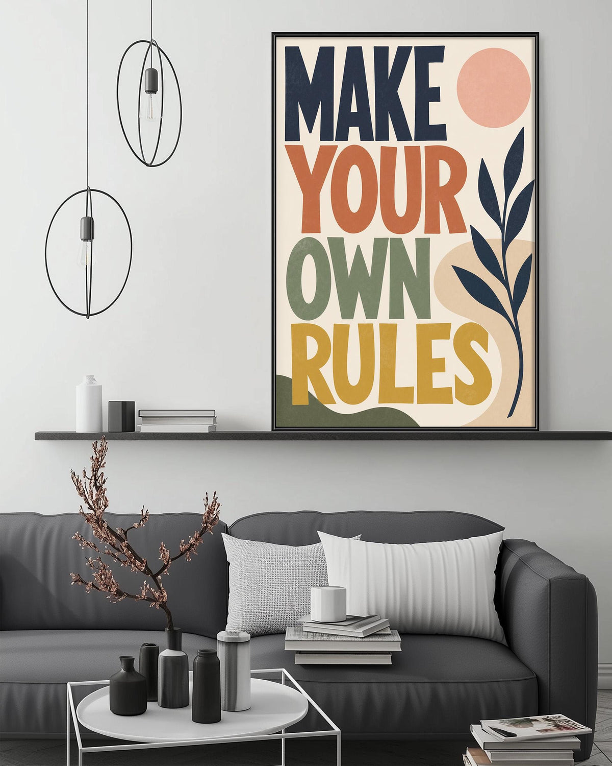a modern living room with a gray sofa, a coffee table, and a large framed poster with the text "MAKE YOUR OWN RULES" displayed on the wall above the sofa.