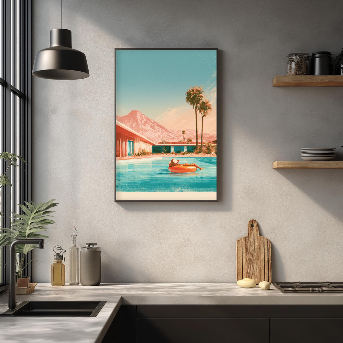 a framed painting of a beach scene with palm trees, a pool, and a person swimming in the water. The painting is hung on a wall above a kitchen counter with various kitchen items such as a cutting board, a bottle, and a vase.