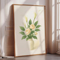 A framed painting of a vase with yellow flowers is displayed on a wall in a room with a window.