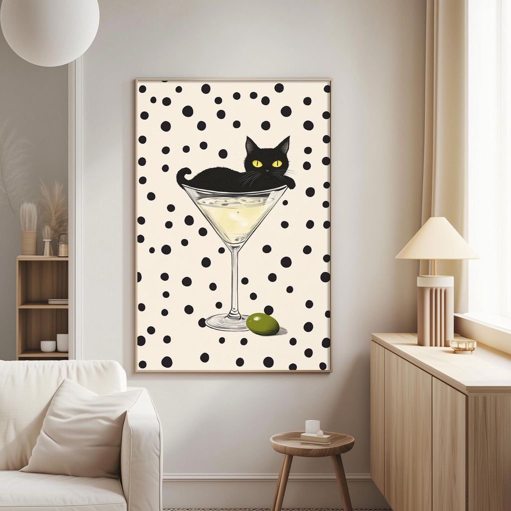 a black cat sitting on a martini glass, which is filled with a yellow liquid, and there is a green olive on the glass.