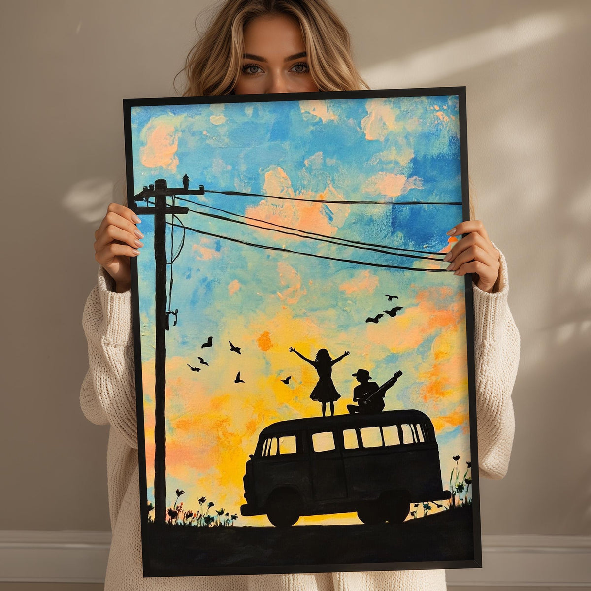 A woman holds up a framed painting depicting a silhouette of a person riding a bus with a bird on top, set against a colorful sky with clouds.
