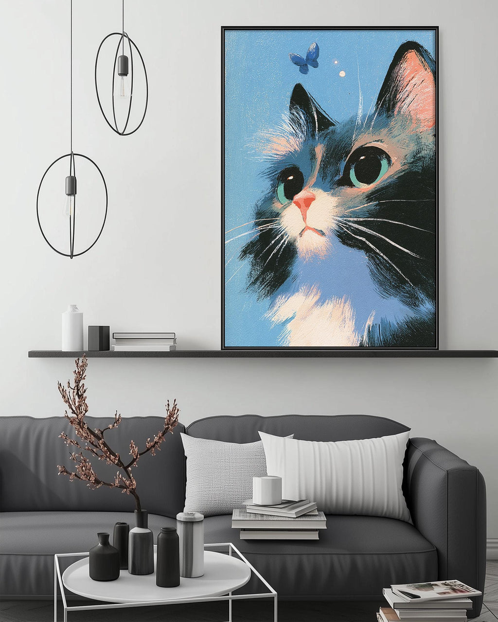 a large framed painting of a cat with a blue background and white and black accents, hanging on a wall above a gray couch with white pillows.