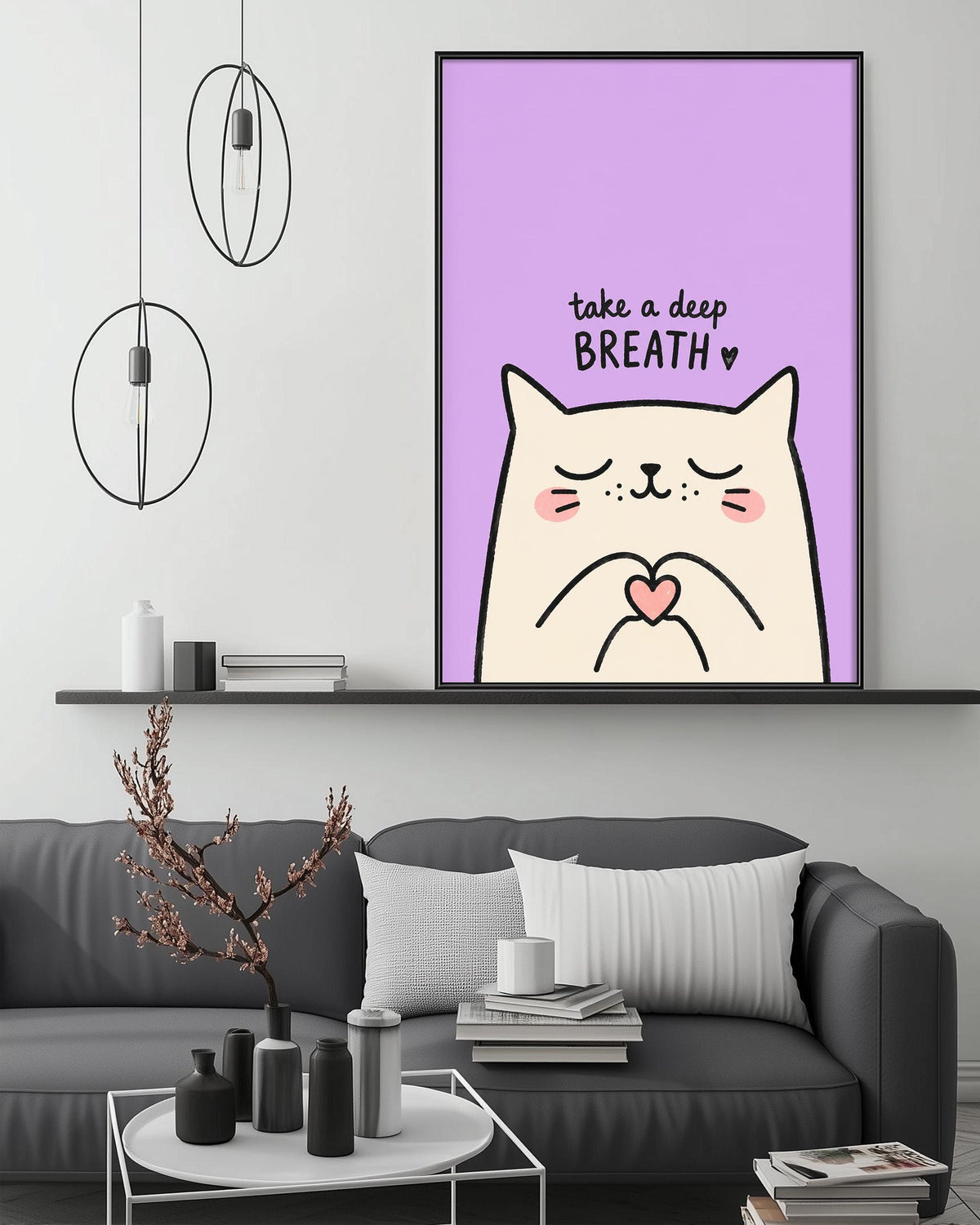 a cozy living room with a gray couch, a coffee table, and a framed poster with a cat and the text "Take a deep breath" on it.
