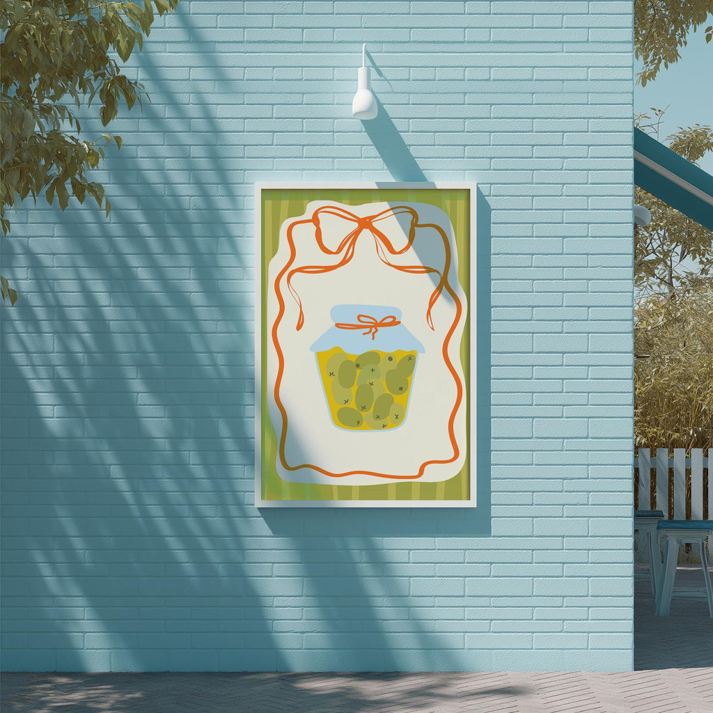 a blue brick wall with a framed illustration of a jar of pickles hanging on it.