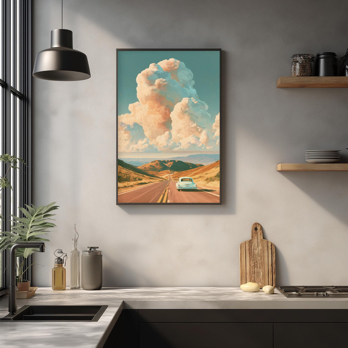 a framed painting of a road leading to a blue car, with a cloudy sky in the background, hanging on a wall above a kitchen counter.