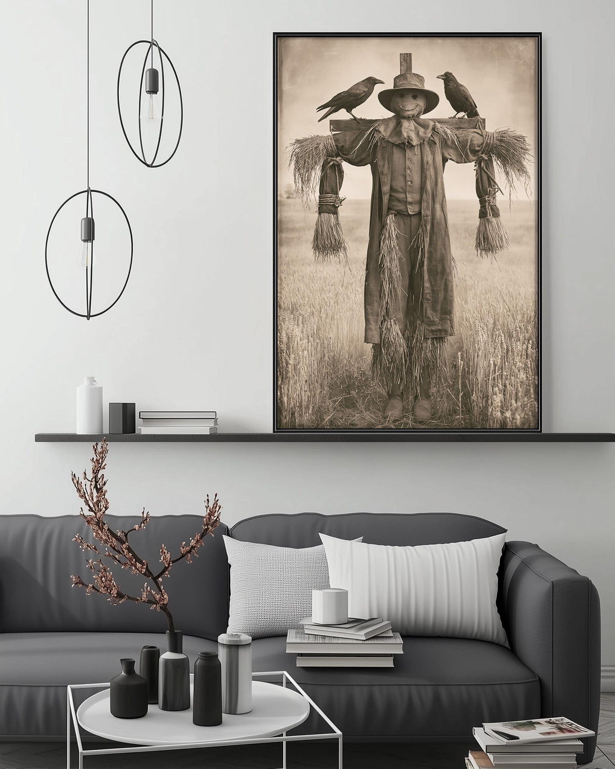 a living room with a gray sofa, a coffee table, and a large framed photograph of a scarecrow with three birds perched on its back. The photograph is mounted on the wall above the sofa, creating a focal point in the room.