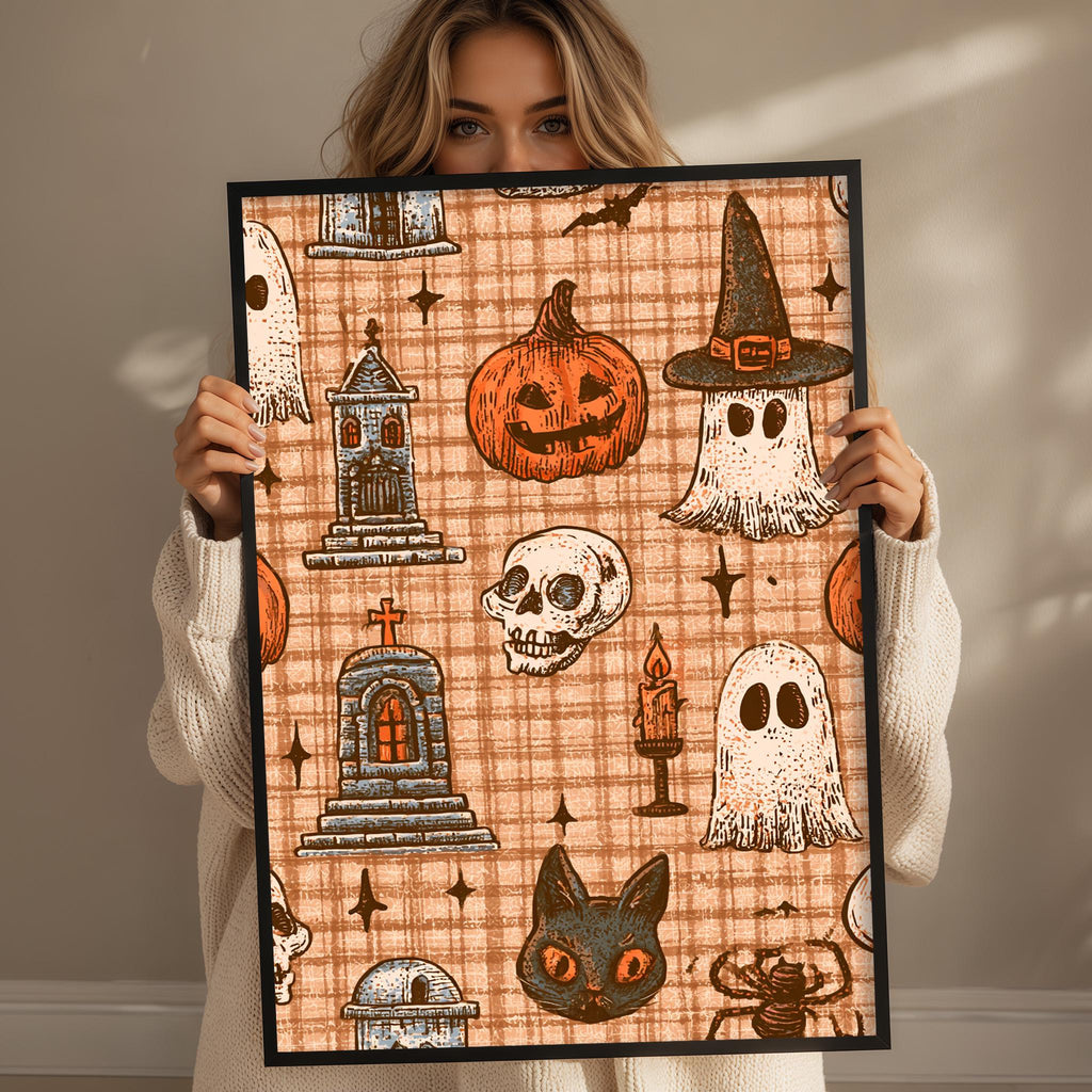 A woman is holding up a framed print with a Halloween-themed pattern featuring various spooky and supernatural elements such as a ghost, skeleton, witch's hat, jack-o-lantern, and a castle.