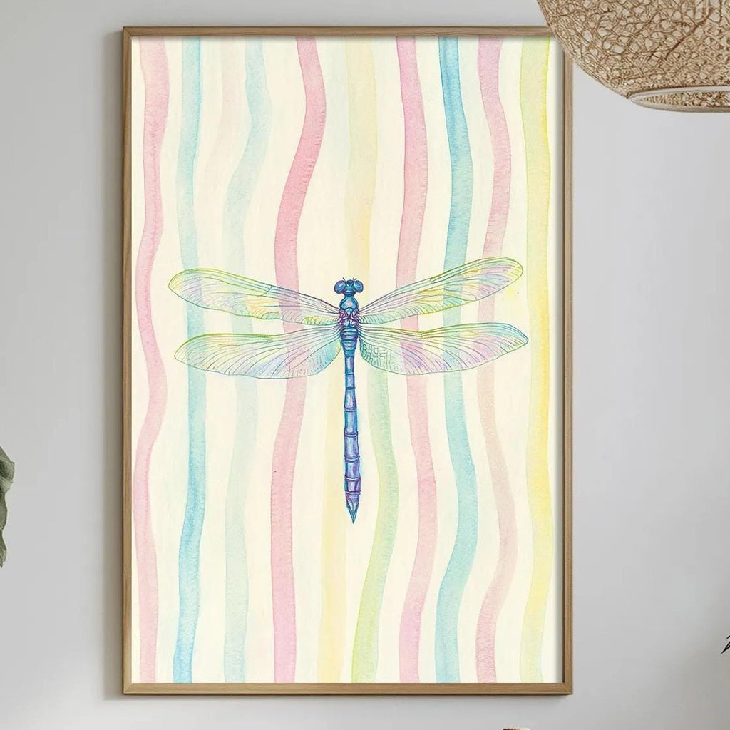 a dining table with a white tablecloth, a bowl of fruit, a bottle, and a vase with flowers. Above the table, there is a framed picture of a dragonfly with a colorful background.