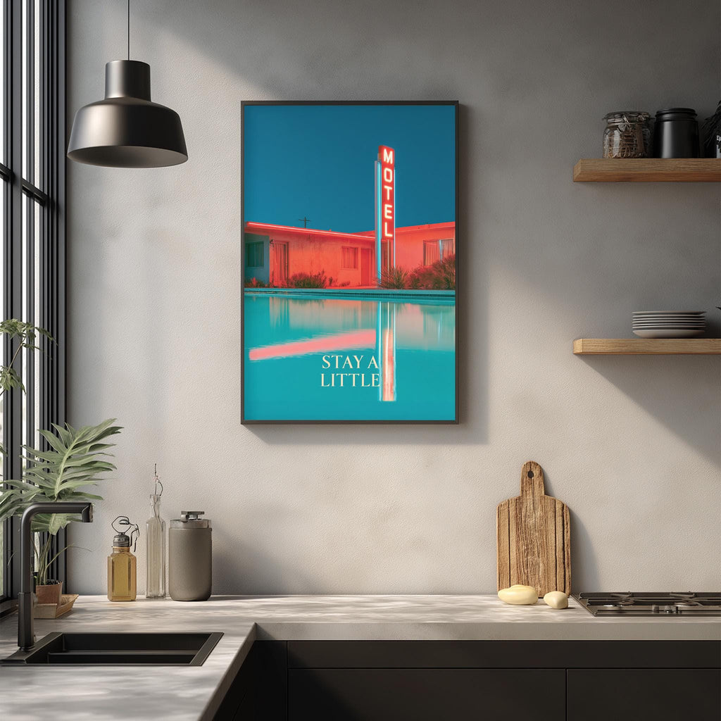 a framed poster of a motel with a pool, hanging on a wall above a kitchen counter with various kitchen items and a wooden cutting board.