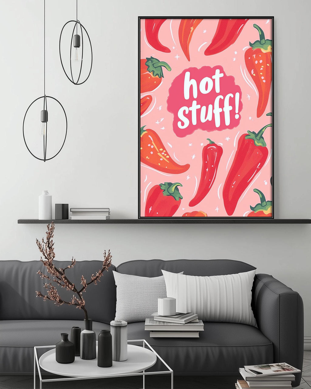 a cozy living room with a gray couch, a coffee table, and a large framed poster with a vibrant design of red peppers and the text "hot stuff!" hanging on the wall above the couch.