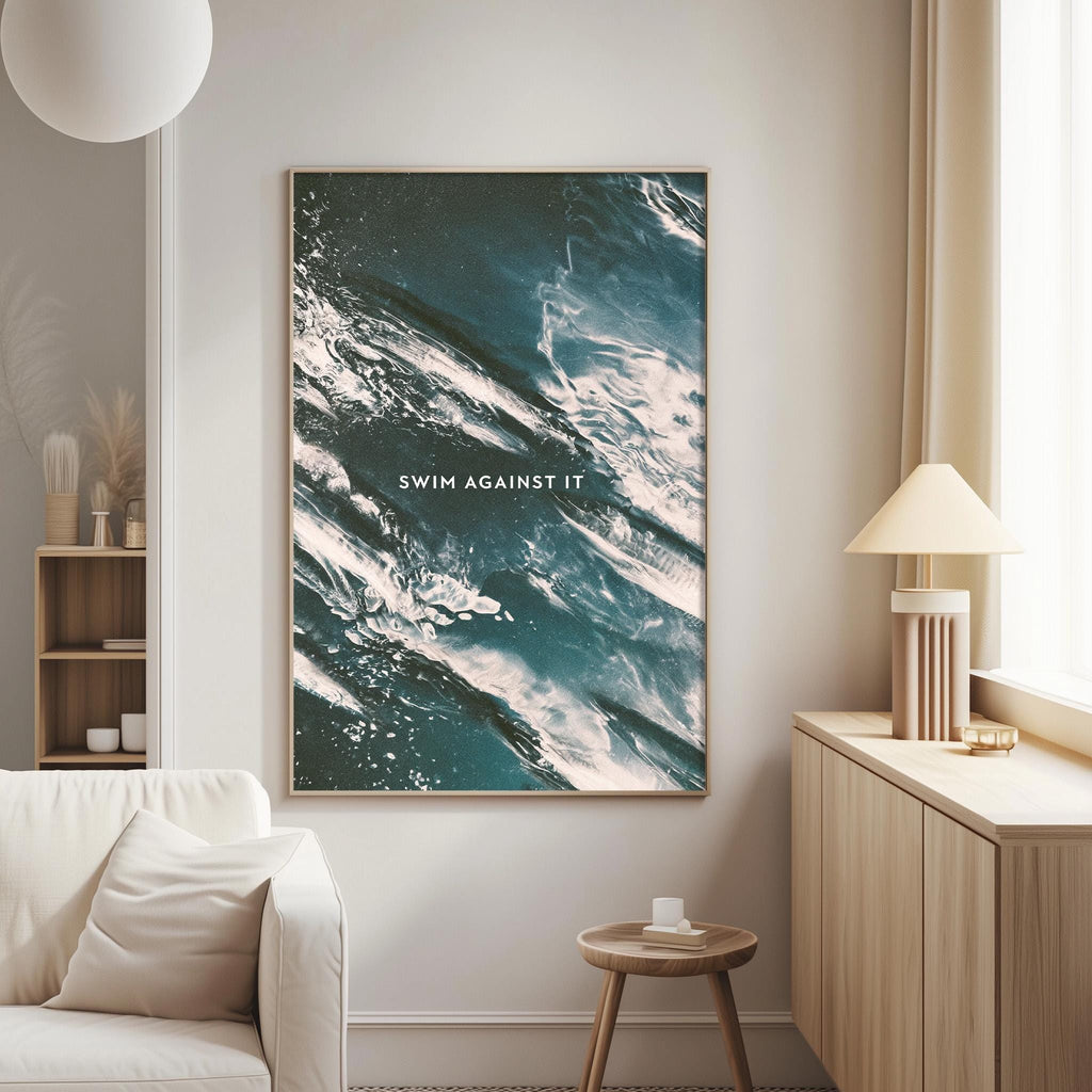 a living room with a large framed poster of a wave on the wall, a white sofa, a wooden side table, and a lamp.