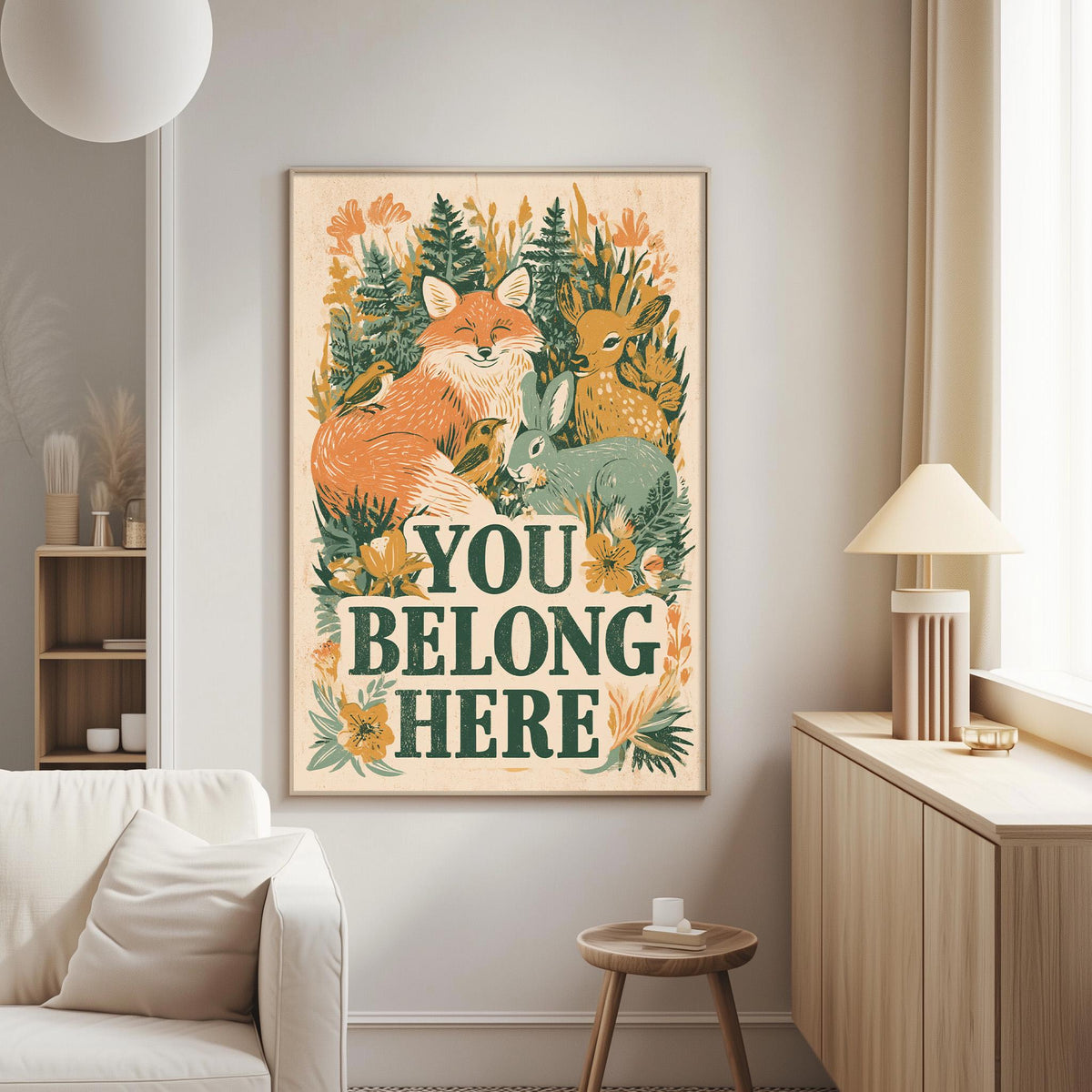 a poster with a forest scene and the text "YOU BELONG HERE" displayed on a wall in a living room setting.