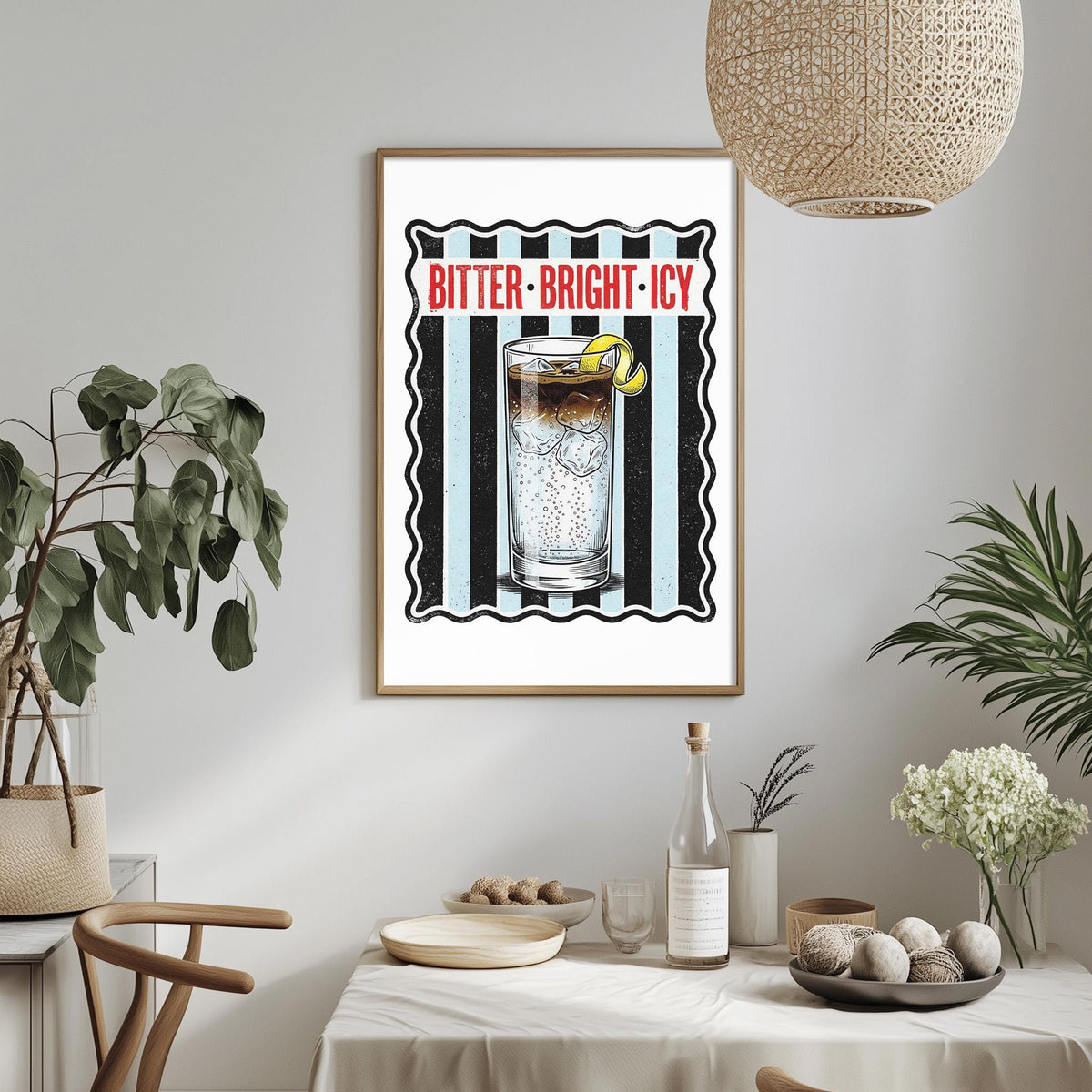 a framed poster of a glass of iced tea with a lemon, hanging on a wall above a dining table with various items on it.