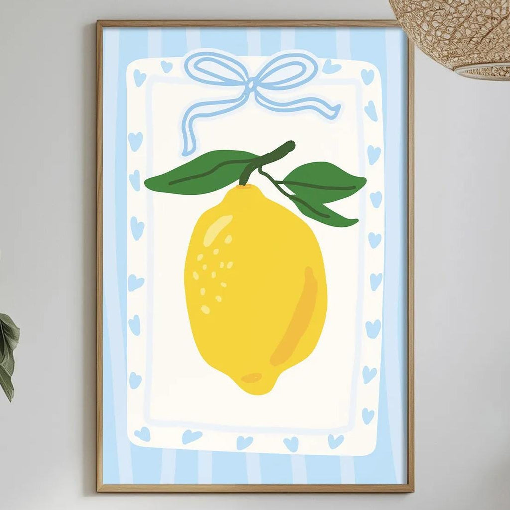 a dining table with a white tablecloth, a bowl of fruit, a bottle, and a vase with flowers. Above the table, there is a framed picture of a lemon with a blue ribbon.