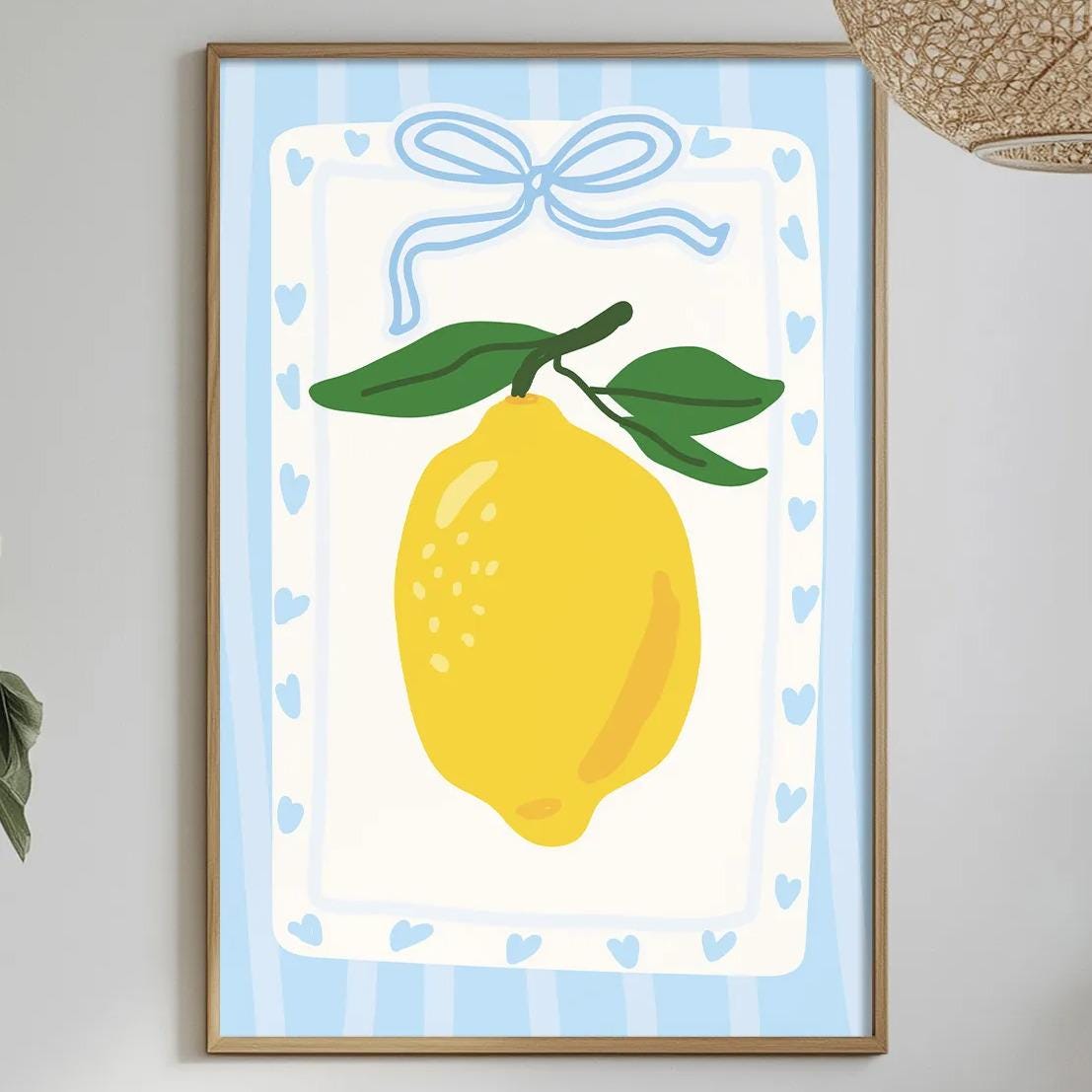 a dining table with a white tablecloth, a bowl of fruit, a bottle, and a vase with flowers. Above the table, there is a framed picture of a lemon with a blue ribbon.