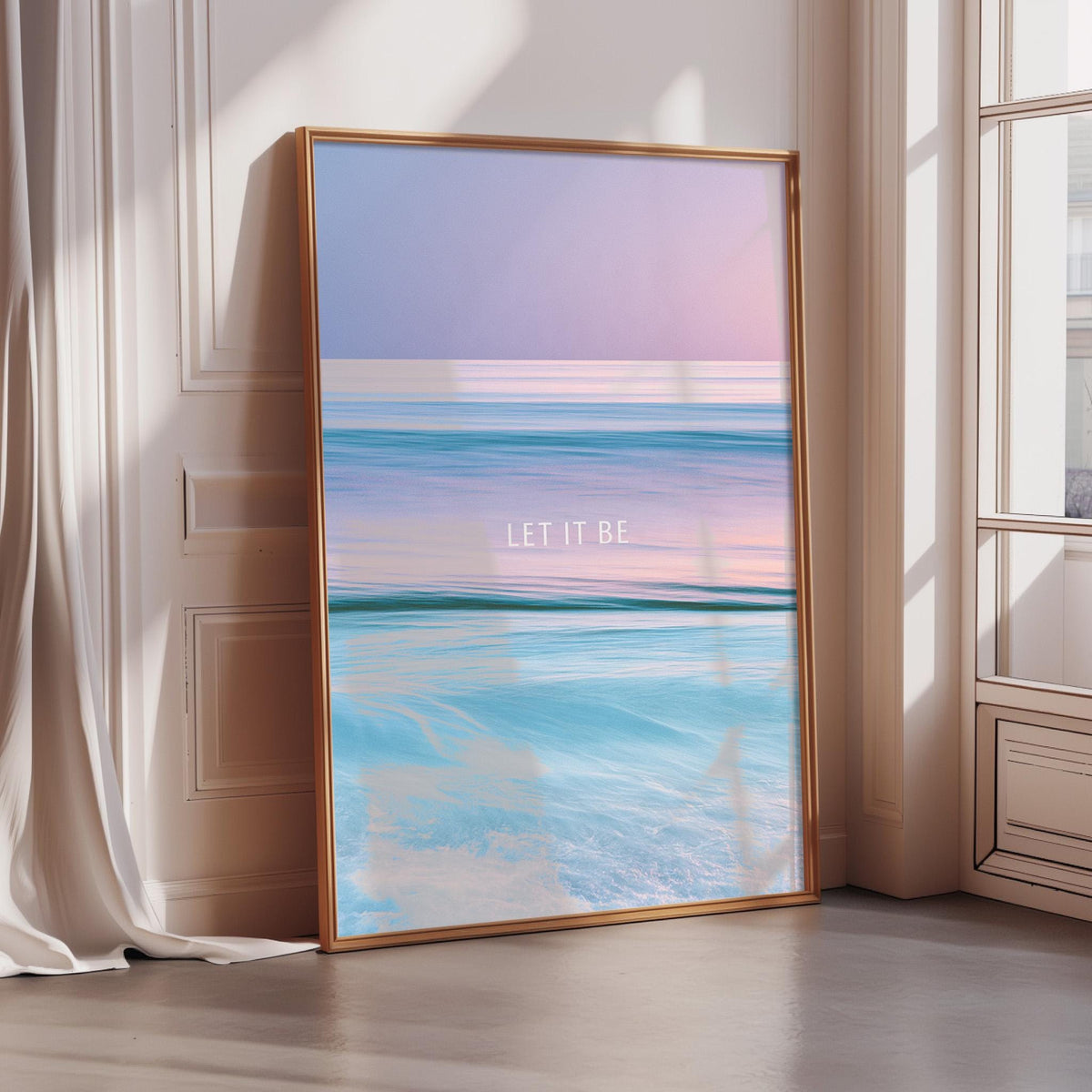 A large framed poster with a seascape design, featuring a gradient of colors and the text "LET IT BE" in the center.