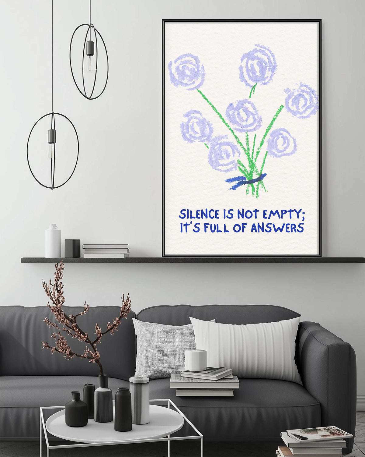 a living room with a gray couch, a coffee table, and a framed poster with a flower design and a message.