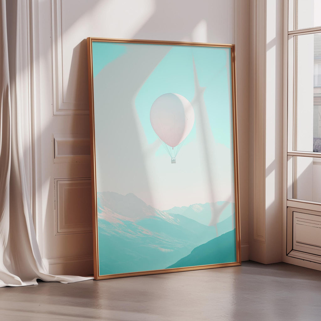 A large framed poster depicting a hot air balloon floating in a mountainous landscape, with a pale blue sky and green mountains in the background.